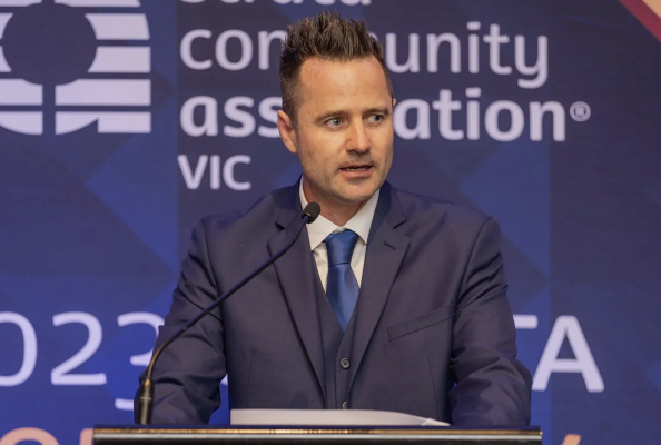 Sam Osborne on stage addressing a full conference room